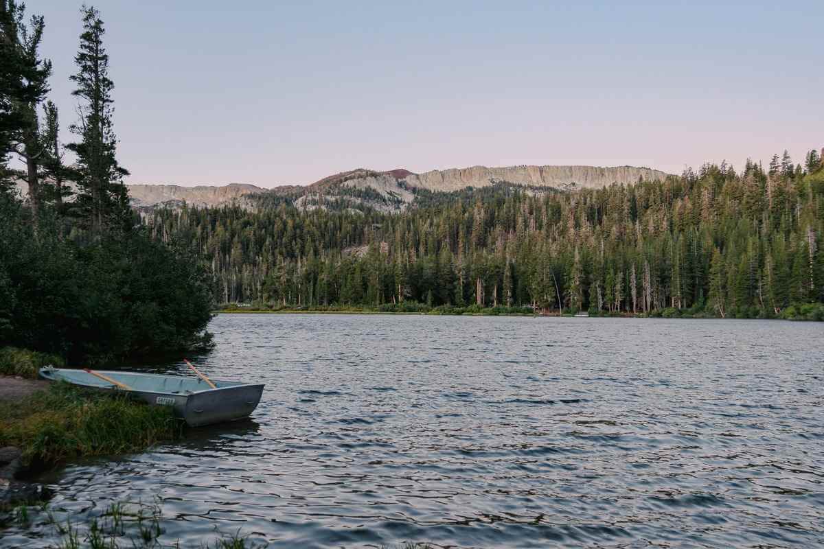 Panoramic view of an Irish lake at sunrise with mist over the water and anglers on the shoreline.
