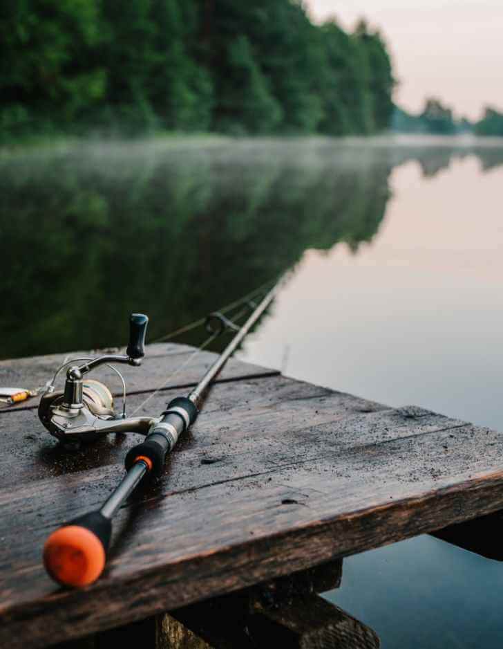 FishBase team member greeting anglers at a lakeside entrance in Ireland.